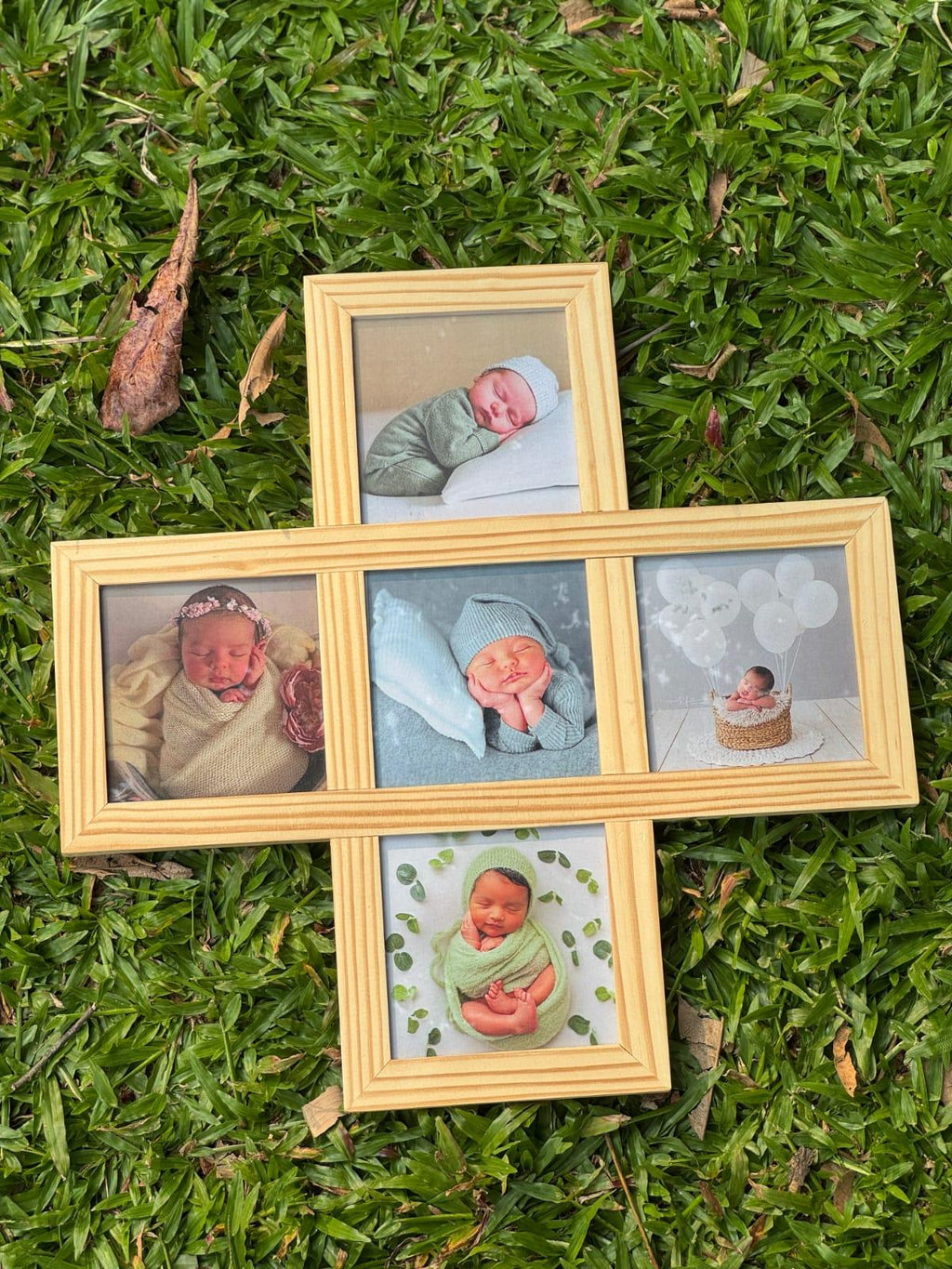 Wooden collage photo frame with baby pictures on green grass